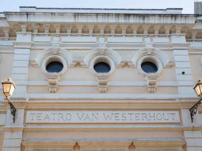 Una lastra marmorea con il nome del teatro e due medaglioni con maschere fa da cornice marcapiano. Oltre quest�ultima si innalza il livello superiore scandito da tre oculi archivoltati retti da doccioni modanati sovrastati da una merlatura che regge una mensola in pietra